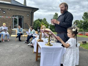 Rev Alfred leading communion outside